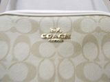a white coach bag with a gold coach logo on it