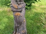 une statue représentant un chat assis dans l'herbe