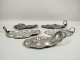 four silver plated dishes on a white surface