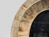 a round mirror with a wooden frame on the wall