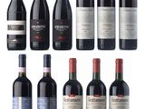 several bottles of red wine are lined up on a white surface
