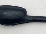 an old black pipe sitting on top of a white surface