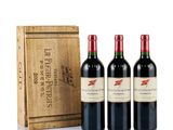 three bottles of red wine in front of a wooden box