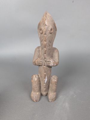 une petite statue représentant un homme assis sur une table
