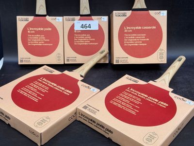Trois raquettes de ping-pong sont posées dans une boîte sur une table.