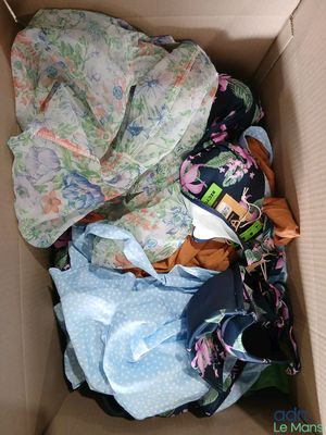 a cardboard box filled with clothes and a blanket