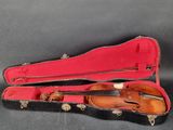 un vieil étui à violon contenant un violon, posé sur une surface noire