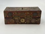 an old wooden box with a lock on it sitting on a white surface