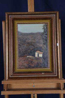 une peinture à l'huile représentant une maison posée sur un chevalet, avec une montagne en arrière-plan