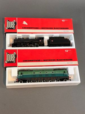 trois trains miniatures dans leurs boîtes, empilés les uns sur les autres