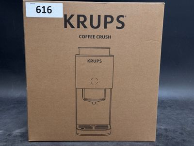 packaging of a coffee grinder sitting on top of a cardboard box