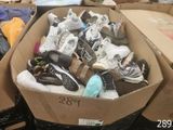 plusieurs paires de chaussures dans une boîte posée sur le sol