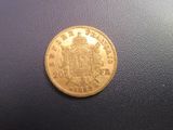 a close up of a gold coin on a black surface