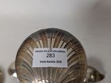 two silver spoons with labels on them sitting on a table