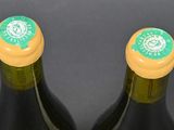 two bottles of wine sitting next to each other on a table