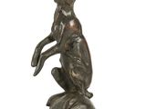 statue représentant un lapin debout sur ses pattes arrière, posée sur un socle en bois