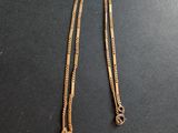 un collier avec une croix en or sur un fond noir