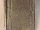 an old book sitting on top of a table next to a cup of coffee