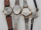 three watches are sitting next to each other on a white surface