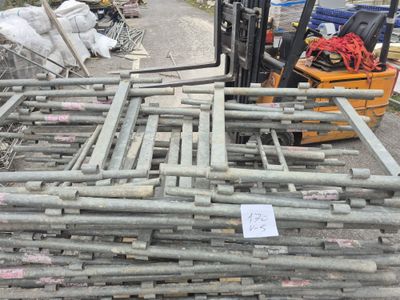 a forklift that is parked next to a pile of pipes