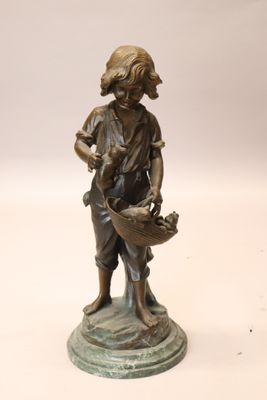 statue en bronze représentant un garçon avec un panier de fleurs