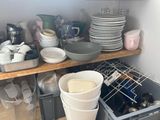 many dishes and cups on the shelves in the kitchen