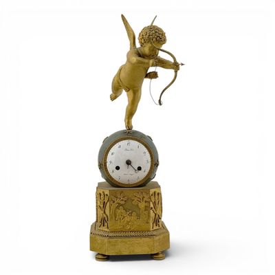 une horloge en or surmontée d'un Cupidon