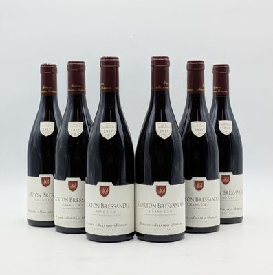 six bouteilles de vin sont alignées sur une surface blanche