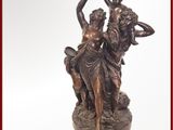 une statue en bronze représentant une femme et deux hommes