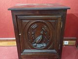 une vieille armoire en bois sur laquelle est sculpté un oiseau