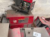 a red machine sitting on top of a table next to other machines