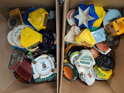 two cardboard boxes filled with assorted items sitting on top of each other