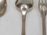 three spoons and a fork on a white surface