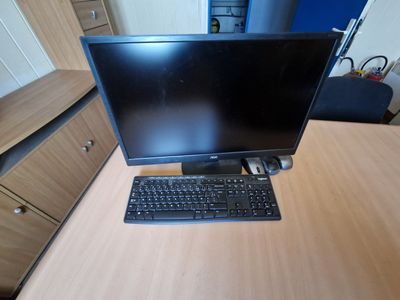 a computer monitor and keyboard on a desk in a room