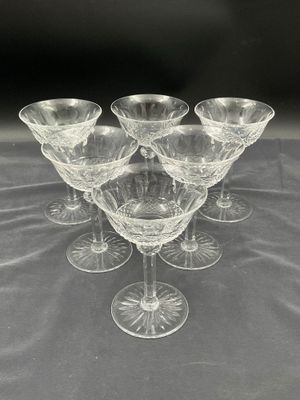 six verres à vin transparents posés les uns à côté des autres sur une table