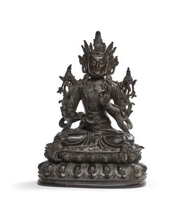 une image représentant une statue en bronze d'une personne assise sur un lotus