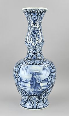 un vase bleu et blanc sur lequel est représentée une femme tenant un parapluie