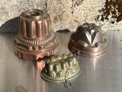trois moules à gâteau posés sur une table en métal