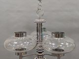 un lustre composé de trois globes en verre suspendus au plafond