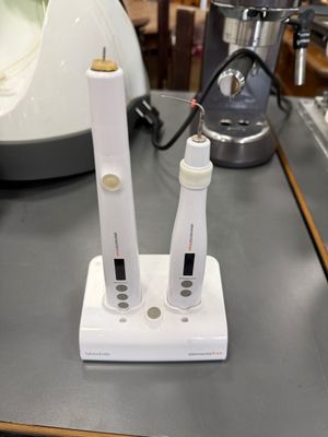 deux brosses à dents électriques posées sur un support posé sur un plan de travail
