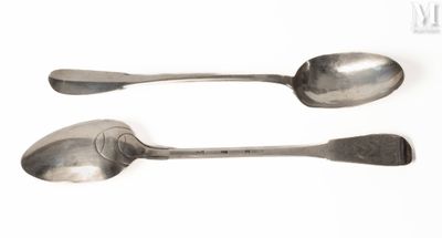 une paire de cuillères en argent posées sur une surface blanche, sur fond blanc