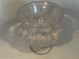a clear glass bowl with a handle on a table
