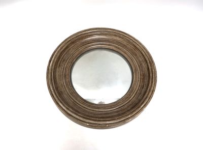 un miroir rond posé sur une table blanche, avec un fond blanc