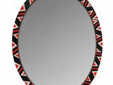 un miroir rond orné de motifs noirs, rouges et blancs