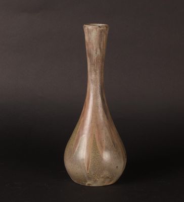 a brown vase that is sitting on a black surface