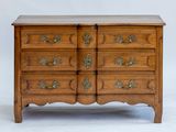 a wooden chest of drawers with brass handles and a marble top