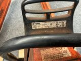 a close up of a black handle on a wooden bench