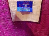 pink and white straw bag with a blue label on it