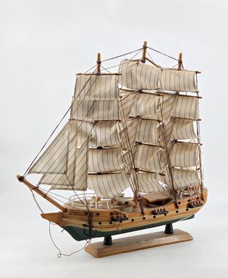a wooden model of a sailboat on a stand
