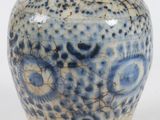 un vase bleu et blanc posé sur une surface blanche